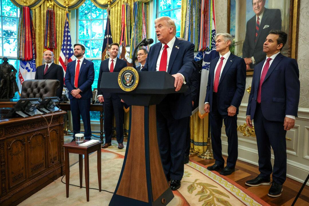President Donald Trump makes an announcement about lowering prescription drug prices as officials look on, including Pfizer CEO Albert Bourla (4th L) in the Oval Office on Sept. 30, 2025. (Brendan SmialowskiI/AFP via Getty Images)