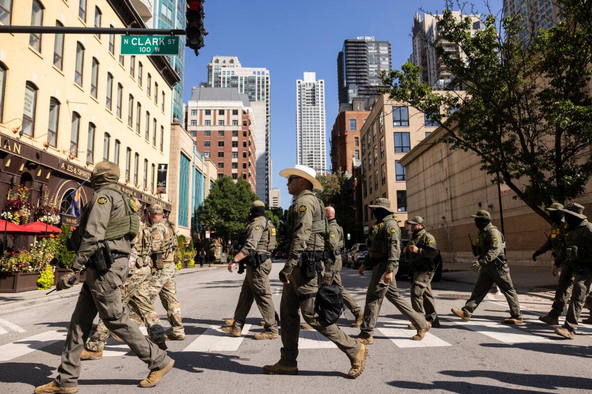 Federal agents from Immigration and Customs Enforcement and Customs and Border Protection walk north on North Clark Street in the River North neighborhood of Chicago on Sept. 28, 2025. (Ashlee Rezin/Chicago Sun-Times via AP)