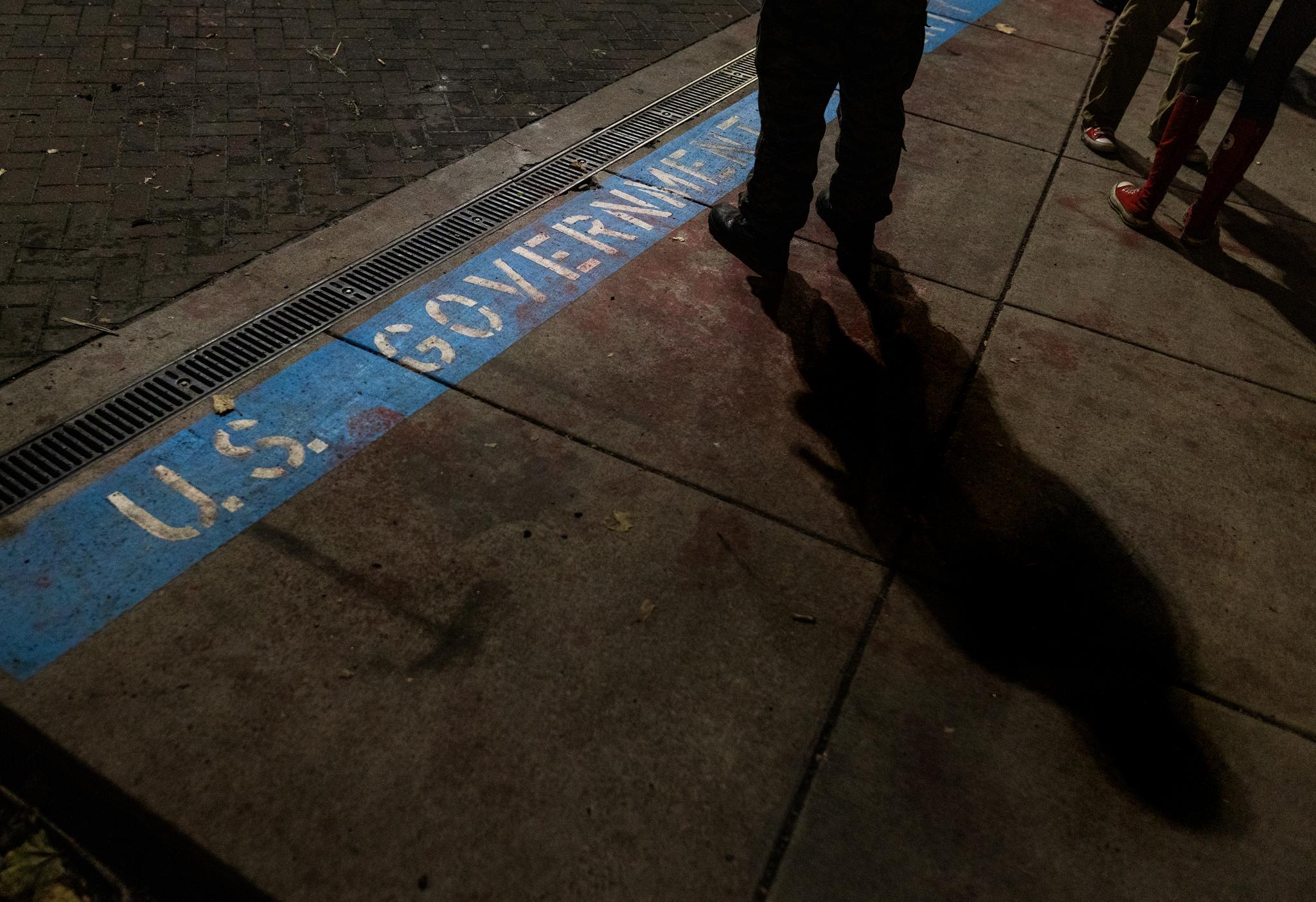 A line separates federal property from the sidewalk amid protests at Immigration and Customs Enforcement offices in Portland, Ore., on Oct. 3, 2025. (John Fredricks/The Epoch Times)