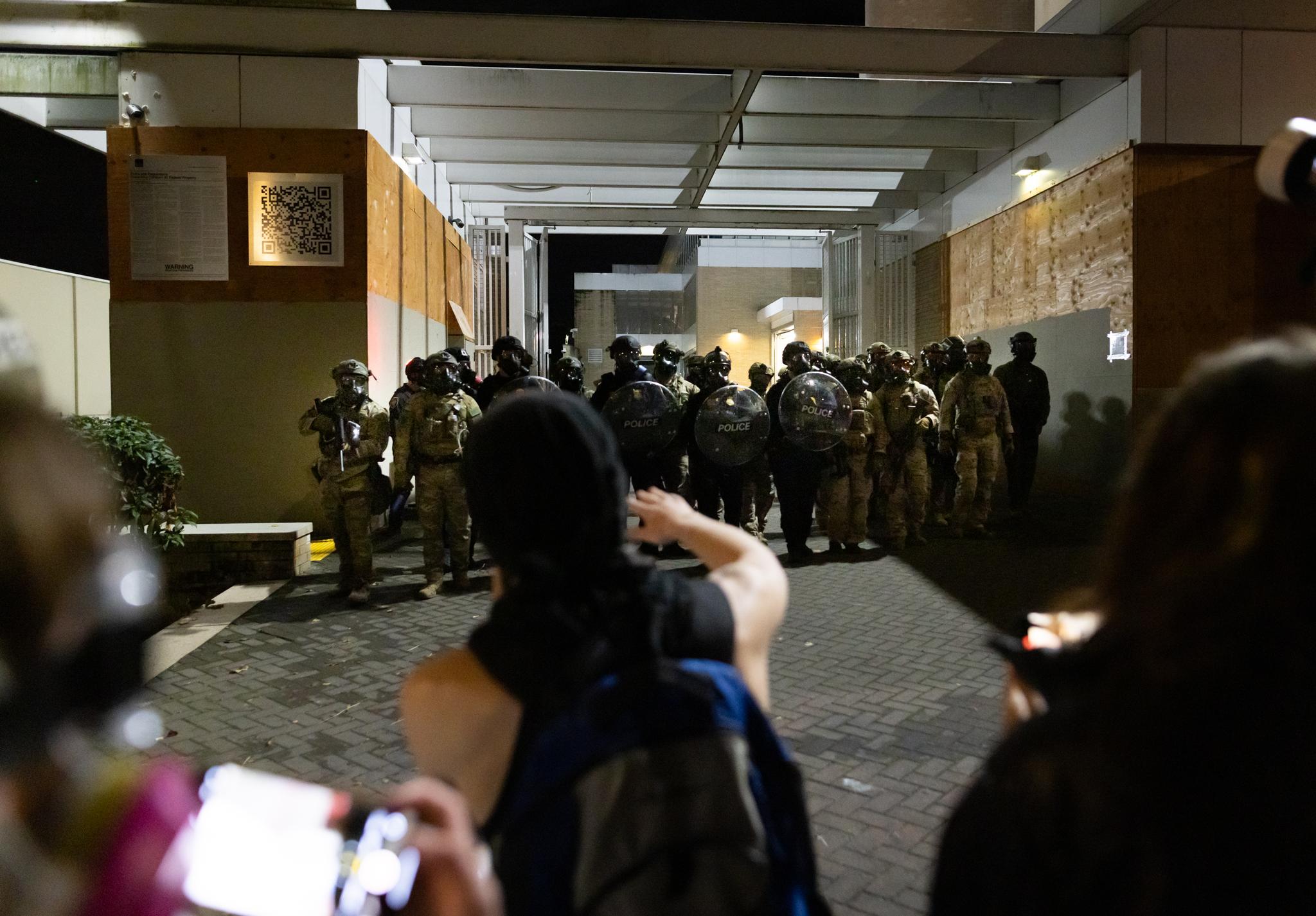 Federal agents and protesters stand in front of Immigration and Customs Enforcement offices in Portland, Ore., on Oct. 3, 2025. (John Fredricks/The Epoch Times)