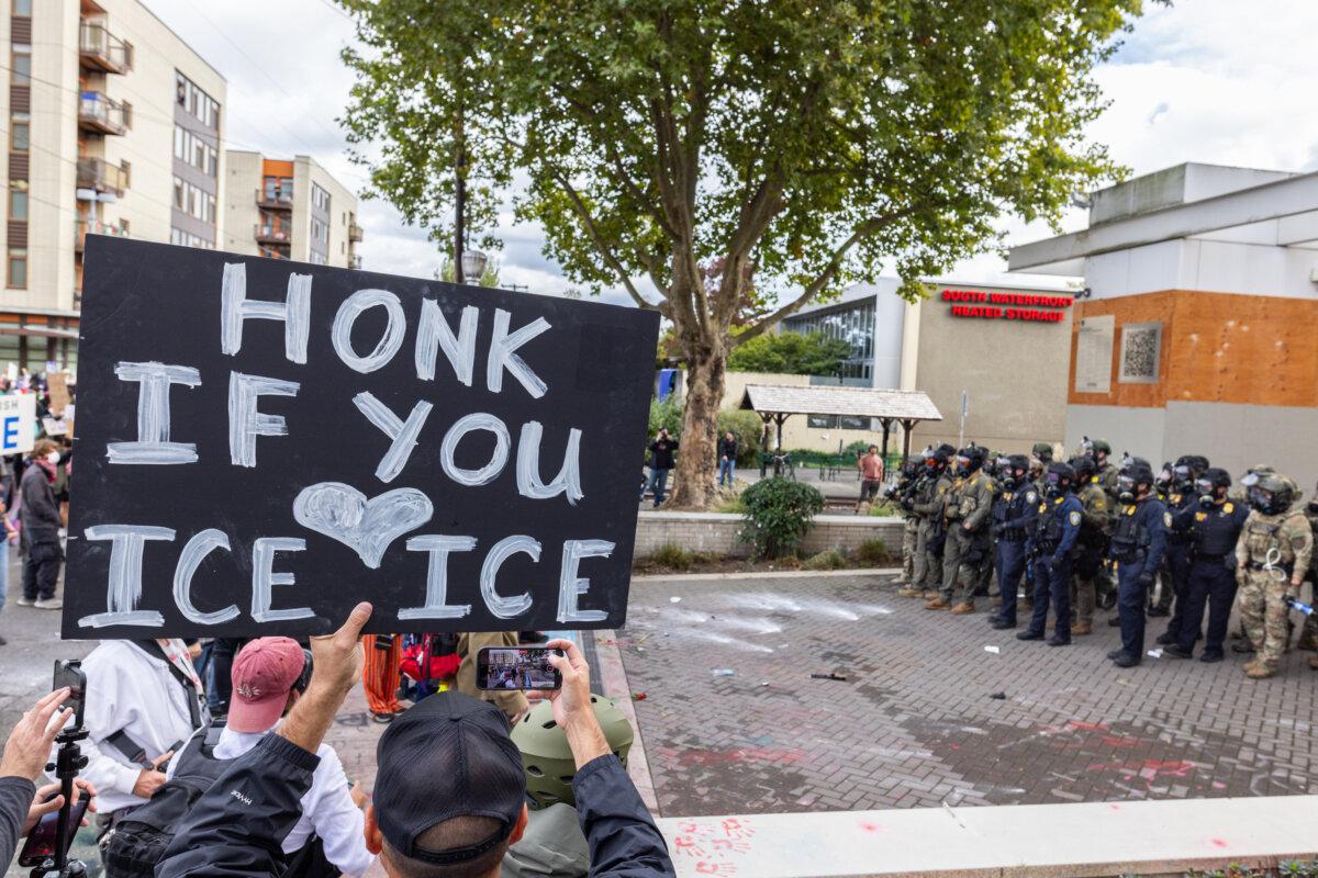 An Immigration and Customs Enforcement supporter stands in front of ICE offices in Portland, Ore., on Oct. 4, 2025. (John Fredricks/The Epoch Times)