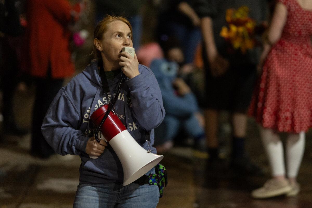 A protester shouts into a megaphone at Immigration and Customs Enforcement offices in Portland, Ore., on Oct. 4, 2025. (John Fredricks/The Epoch Times)