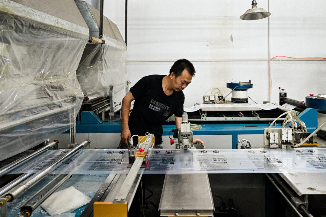 A worker handles packages for Weijiang International, a delivery firm serving the Chinese-founded online shopping giant Temu, in Guangzhou, Guangdong Province, China, on Aug. 12, 2025. In February, President Donald Trump declared the narcotics crisis a national emergency and later imposed a 20 percent tariff on Chinese goods, citing China’s role in supplying fentanyl precursors and laundering cartel money. (Adek Berry/AFP via Getty Images)