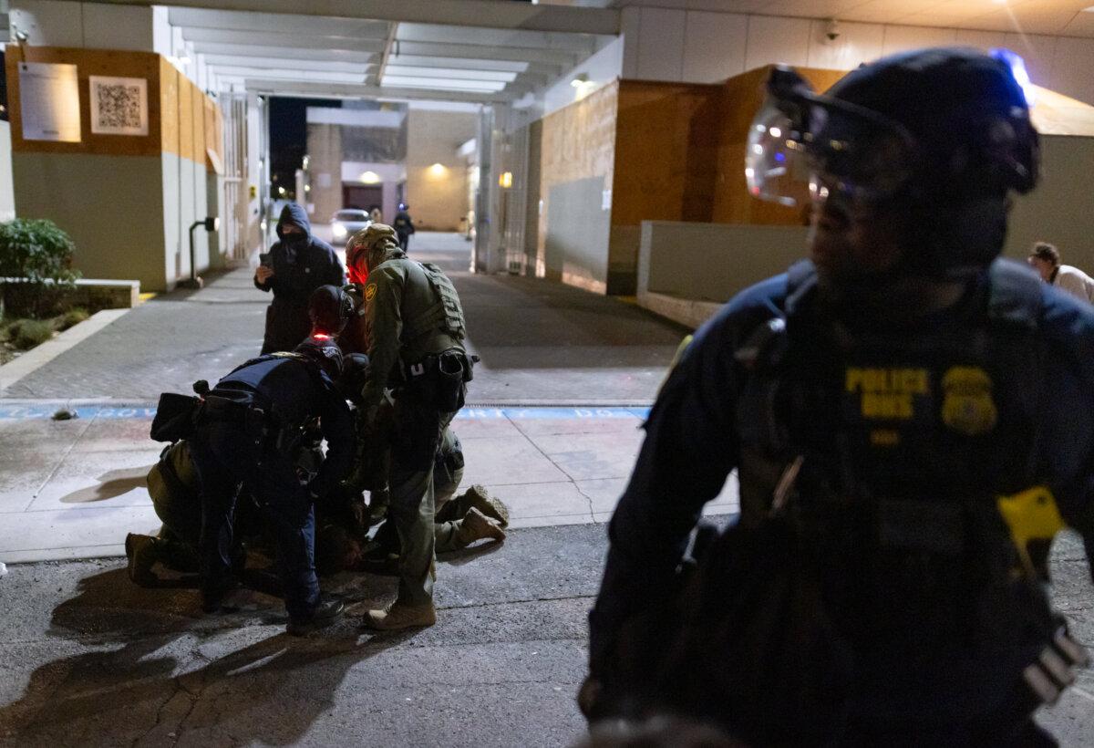 A man is arrested by federal officers in front of Immigration and Customs Enforcement offices in Portland, Ore., on Oct. 5, 2025. (John Fredricks/The Epoch Times)
