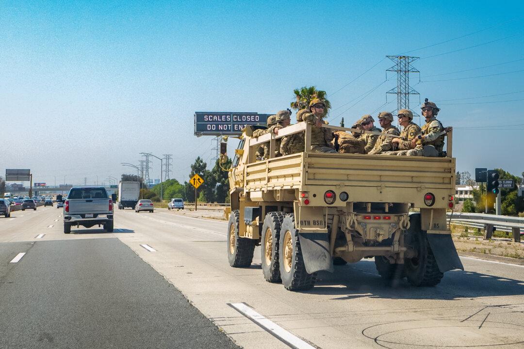A military unit travel along Interstate 405 while responding to rioting in Los Angeles on June 10, 2025. (John Fredricks/The Epoch Times)