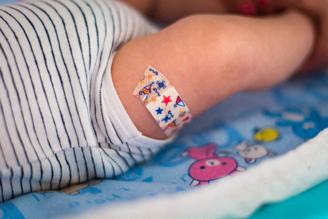 Illustration of a baby after his first hexavalent vaccination, with a Band-Aid placed on his thigh, in this file image. Advisers to the Centers for Disease Control and Prevention are reviewing the childhood immunization schedule, which has grown from five vaccines in 1995 to about a dozen today. (Riccardo Milani/AFP via Getty Images)