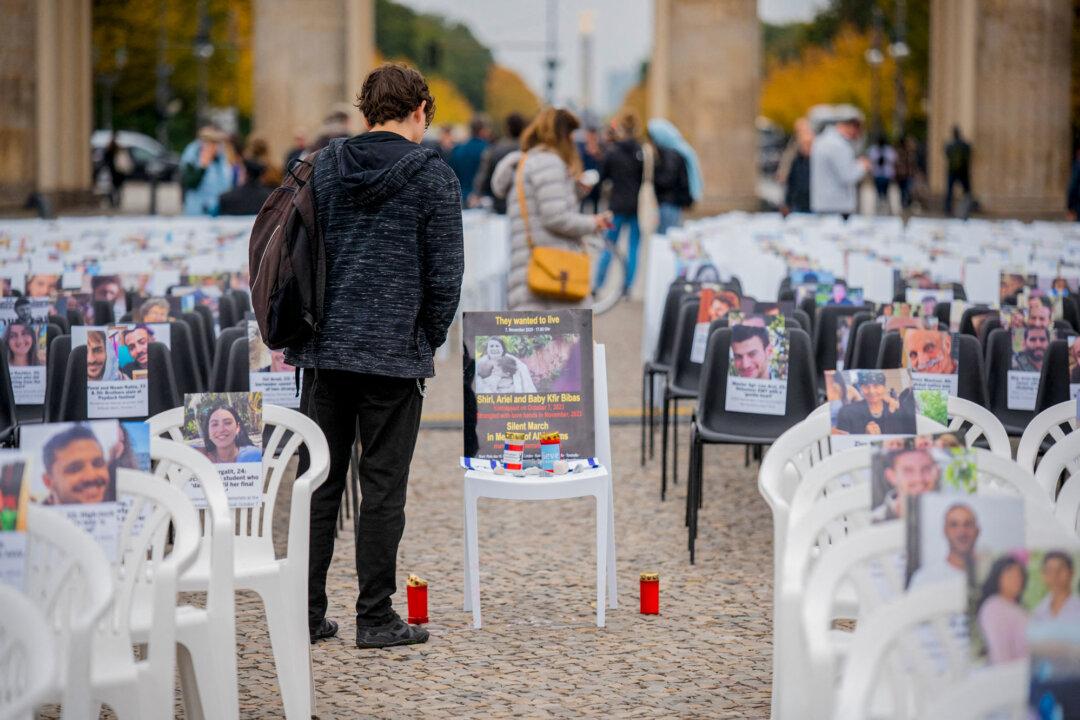 People visit rows of empty chairs bearing photos of Israeli victims and hostages displayed during a memorial vigil in front of the Brandenburg Gate in Berlin on Oct. 7, 2025. The installation, featuring more than 1,000 chairs, was organized by the Jewish Student Union Germany to commemorate the victims of the Oct. 7, 2023, Hamas attack on Israel. (Stefan Frank/Middle East Images/AFP via Getty Images)