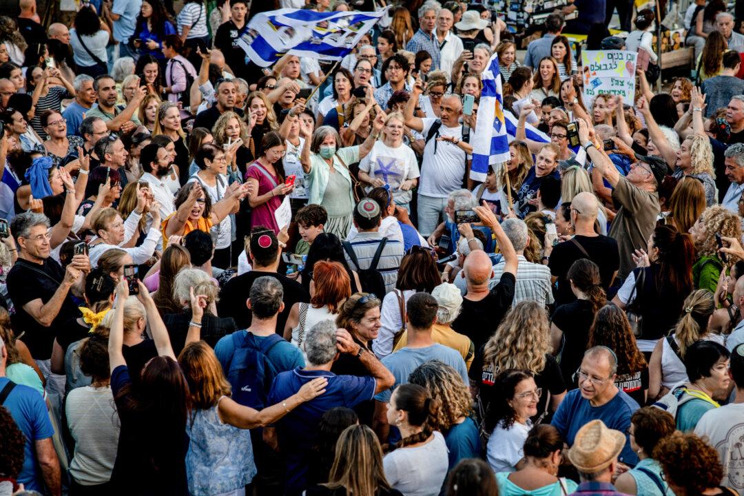 People gather and wave flags as they react to the news of the Israel–Hamas peace deal, in what's known as Hostages Square in Tel Aviv, Israel, on Oct. 9, 2025. (Chris McGrath/Getty Images)