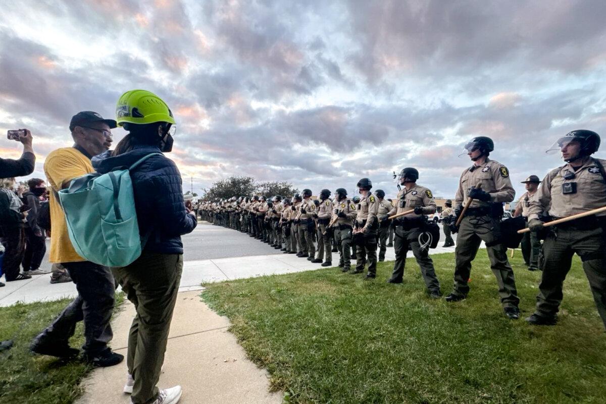 Illinois State Police stand guard as people protest in front of the Immigration and Customs Enforcement detention facility in Broadview, Ill., on Oct. 11, 2025. (NTD)