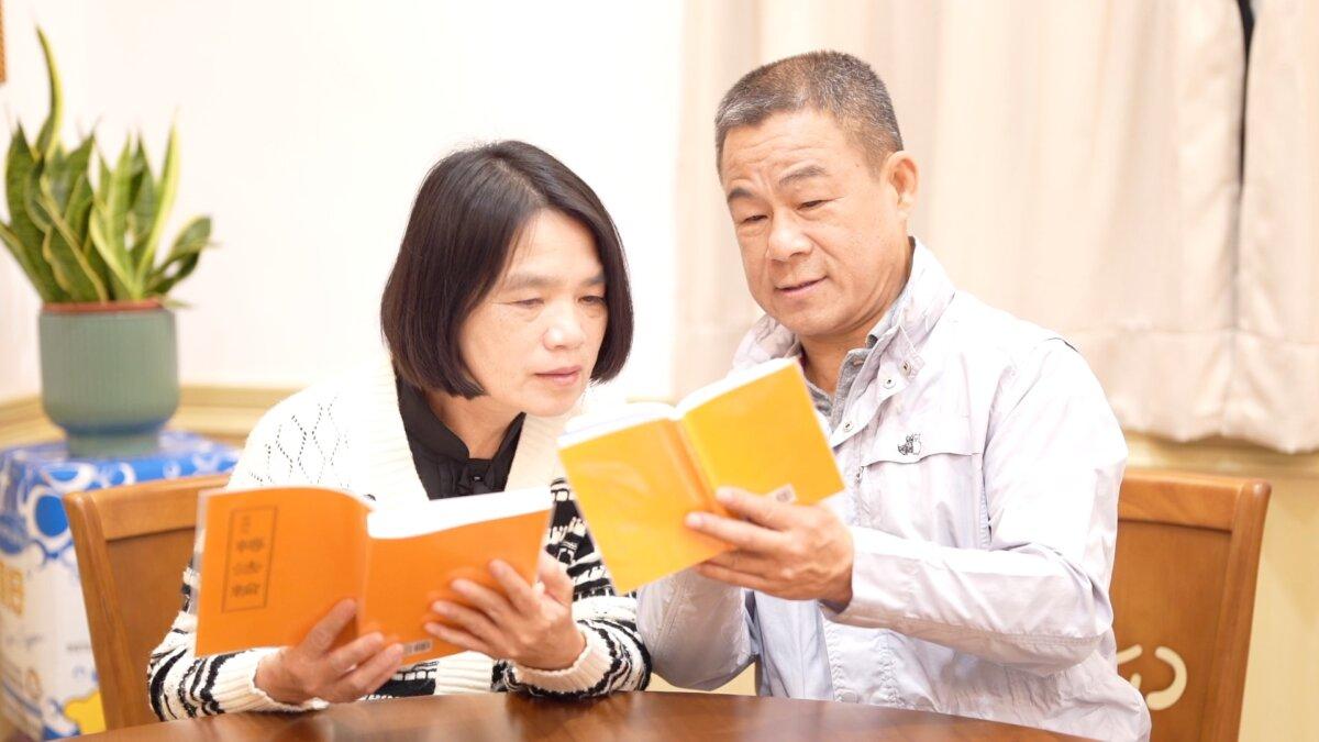 Taiwanese entrepreneur Huang Chaoming (R) and his wife reads Zhuan Falun, the principle text for Falun Gong. (NTD)