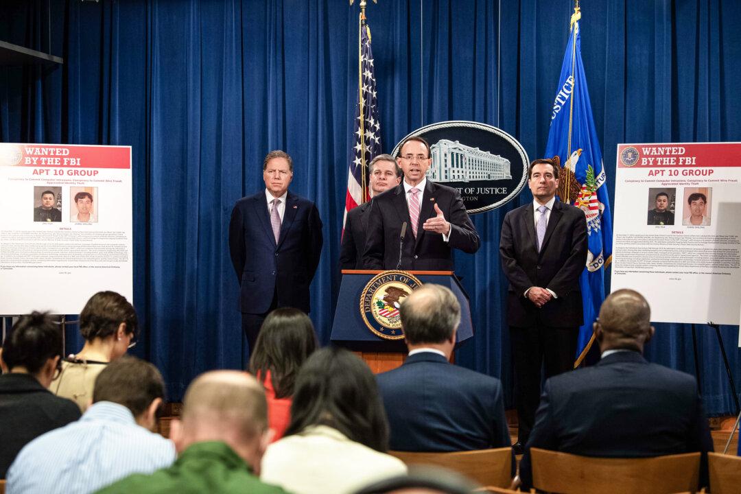 U.S. Deputy Attorney General Rod Rosenstein speaks at a news conference about Chinese hacking with (L–R) U.S. Attorney for the Southern District of New York Geoffrey Berman, FBI Director Christopher Wray, and Assistant Attorney General for National Security John Demers at the Justice Department in Washington on Dec. 20, 2018. The Justice Department announced indictments of Chinese government hackers who allegedly targeted scores of companies in a dozen countries. (Nicholas Kamm/AFP via Getty Images)