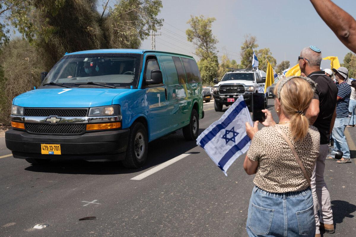 Israelis gather with national flags outside the Reim military base to welcome the hostages, near the border with Gaza in southern Israel on Oct. 13, 2025 .(Maya Levin/AFP via Getty Images)