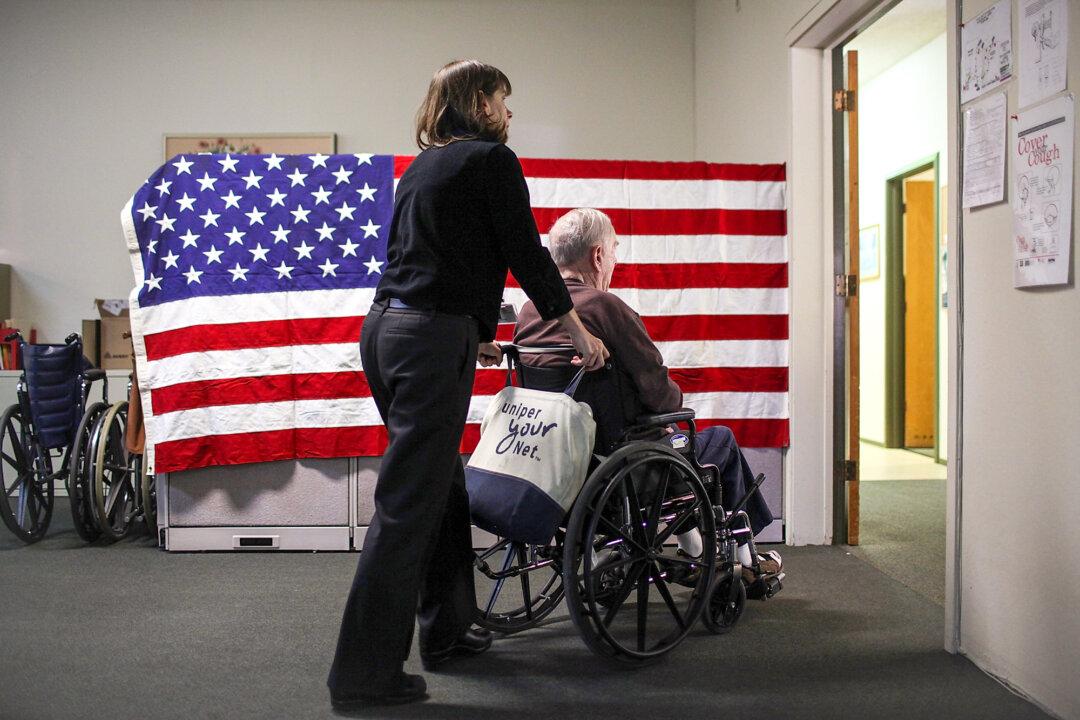 A woman pushes Fred Lear in a wheelchair after he had a physical therapy session at the LifeLong Medical Marin Adult Day Health Care Center in Novato, Calif., on Feb. 10, 2011. (Justin Sullivan/Getty Images)