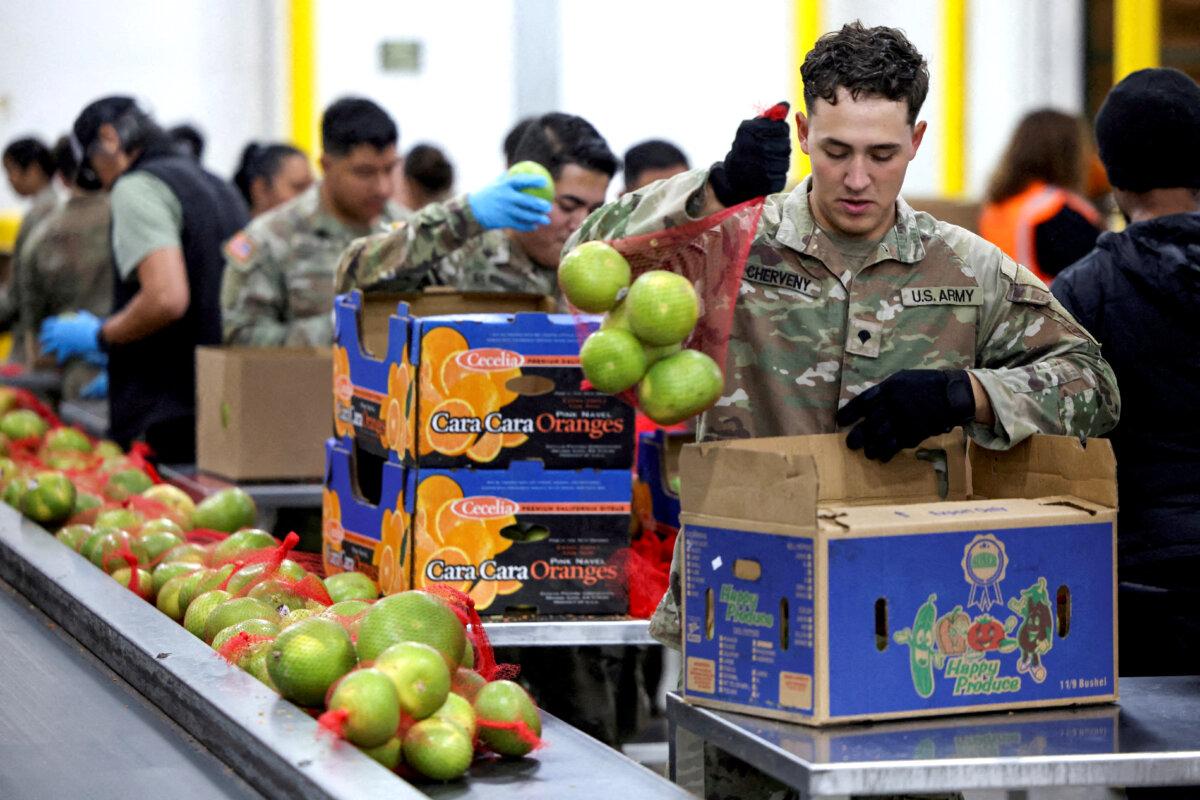 A member of the National Guard packs food at a Los Angeles Regional Food Bank facility, as nearly 42 million Americans face a potential lapse in Supplemental Nutrition Assistance Program (SNAP) benefits, known as food stamps, due to the second-longest U.S. government shutdown, in Los Angeles on Oct. 29, 2025. (Daniel Cole/Reuters)