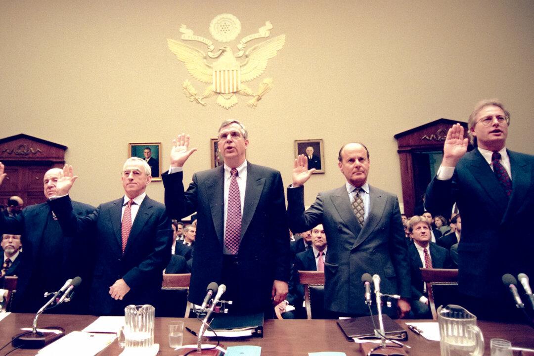 (L–R) Loews Corp. CEO Laurence Tisch, Philip Morris Chairman Geoffrey Bible, U.S. Tobacco CEO Vincent Gierer Jr., RJR Nabisco CEO Steven Goldstone, and Brown & Williamson Chairman Nicholas Brooks are sworn in before testifying to the House Commerce Committee in Washington on Jan. 29, 1998. Legal analysts draw parallels between climate lawsuits and tobacco lawsuits, in which 45 companies settled with states in 1998, agreeing to pay them more than $200 billion over 25 years. Cigarettes remained on the market following the lawsuit, but at much higher prices. (Jessica Persson/AFP via Getty Images)