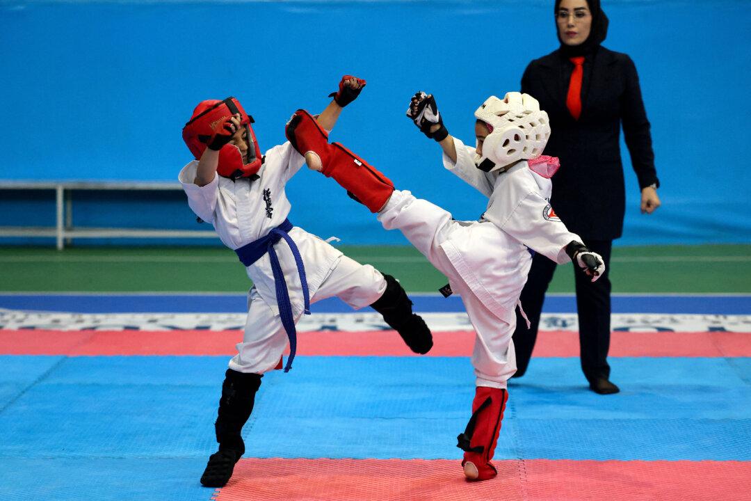 A referee watches Iranian girls during an all-women's karate competition made up from clubs and teams from around the Tehran province, in Tehran, Iran, on Nov. 6, 2025. (Atta Kenare/AFP via Getty Images)