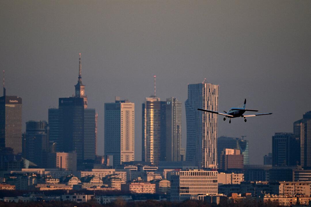 A Piper Cherokee Warrior II airplane lands at Warsaw Babice Airport with Warsaw's skyscrapers in the background, as seen from the village of Klaudyn, Masovian Voivodeship, Poland, on Nov. 6, 2025. (Sergei Gapon/AFP via Getty Images)
