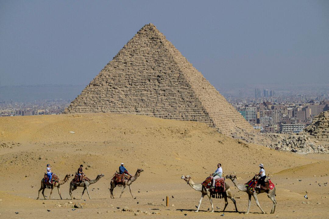 Tourists ride camels at the Giza Pyramids necropolis on the outskirts of Giza, Egypt, on Nov. 7, 2025. (Khaled Desouki/AFP via Getty Images)