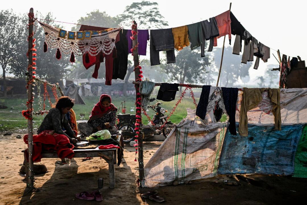 Women prepare samosas, a South Asian snack, at their makeshift shelter under a bridge in New Delhi on Nov. 7, 2025. (Arun Sankar/AFP via Getty Images)