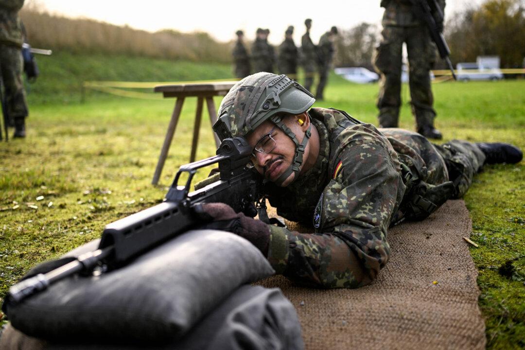 A recruit of the German armed forces Bundeswehr lies on the ground holding a G36 assault rifle on Nov. 13, 2025, on a military base in Ahlen, Germany, during a media day about the basic training for Bundeswehr recruits. Politicians of the ruling German government coalition have agreed on a joint model for the country's new military service on Nov. 13, 2025. (Ina Fassbender/AFP via Getty Images)