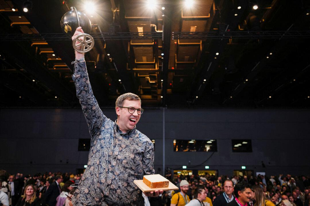 Swiss cheesemaker Pius Hitz, from the Vorderfultigen cheese company, raises the trophy after winning the first prize at the World Cheese Awards with a Gruyere AOP “special over 18 months” cheese, during the 37th edition of the World Cheese Awards, organized by the Guild of Fine Food in Bern, Switzerland, on Nov. 13, 2025. (Gabriel Monnet/AFP via Getty Images)