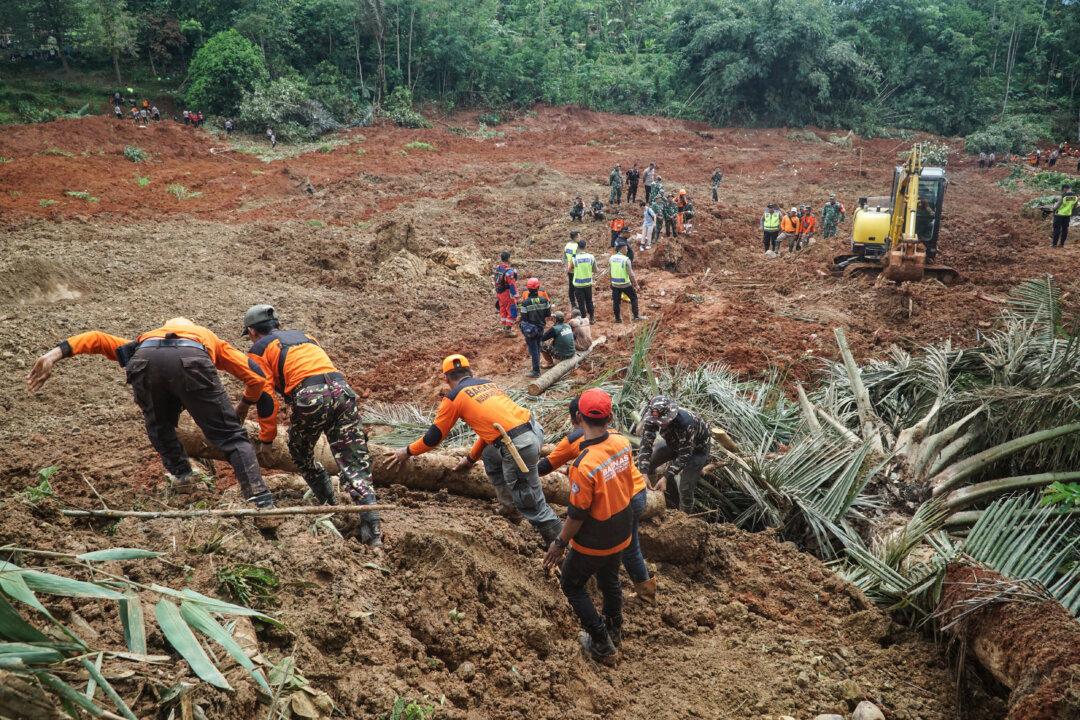 Rescuers search for survivors after a landslide buried homes in Cibeunying village in Cilacap, Indonesia, on Nov. 14, 2025. Officials said two people were confirmed dead and more than 20 were missing. (Bakhtiar Rahman/AFP via Getty Images)