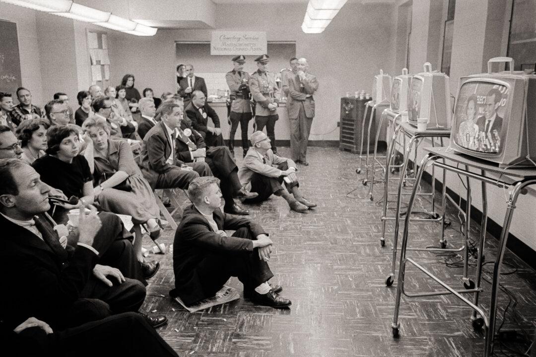 Supporters of Democratic presidential candidate John Fitzgerald Kennedy and reporters await the results of the second round of the presidential election at the National Guard Armory in Hyannis Port, Mass., on Nov. 8, 1960. (AFP via Getty Images)