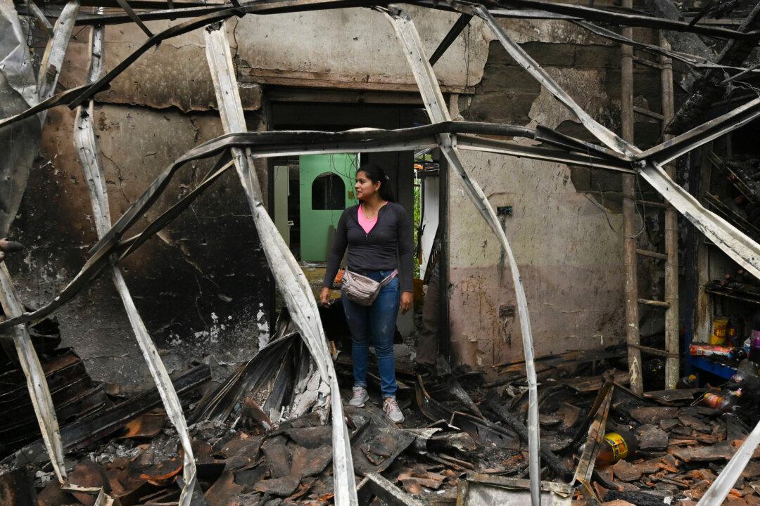 A woman checks damages following an attack at a nearby police station, in Mondomo, Santander de Quilichao, department of Cauca, Colombia, on Nov. 15, 2025. (Joaquin Sarmiento/AFP via Getty Images)