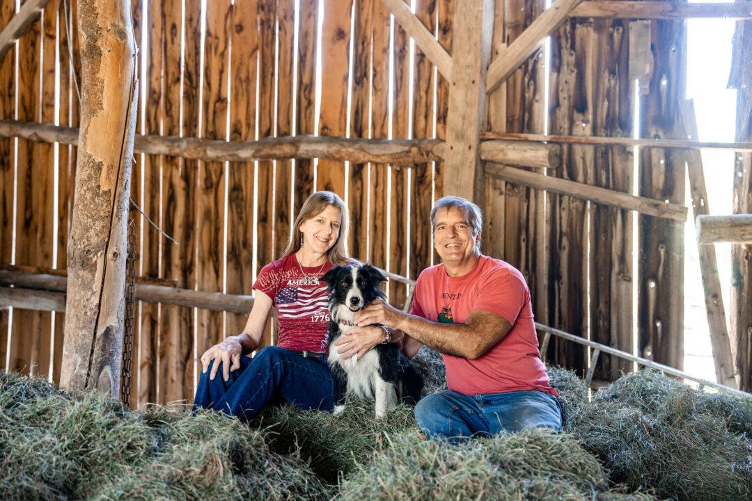 Farmer and lawyer John Klar and his wife, Jacqui, sit with their dog Bea in their barn in Brookfield, Vt., on Sept. 12, 2025. (Samira Bouaou/The Epoch Times)