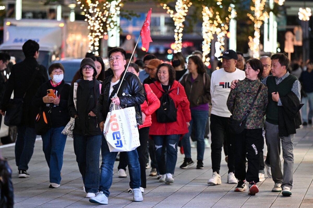 A Chinese tour group walks in the Ginza shopping district in Tokyo on Nov. 17, 2025. (Greg Baker/AFP via Getty Images)