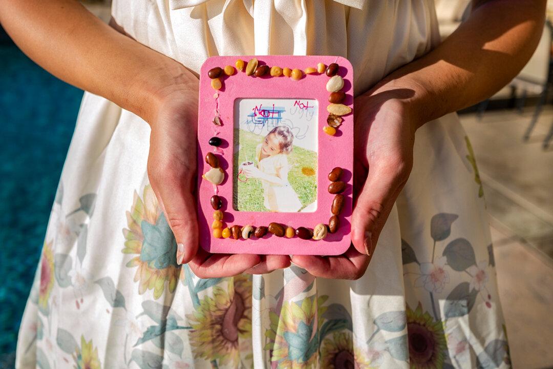 Chloe Cole holds a childhood photo in Northern California on Aug. 26, 2022. Cole recalled that around fourth grade she started to have difficulty coping with her body beginning to mature—‘a common sentiment amongst people who have either ADHD or autism.’ (John Fredricks/The Epoch Times)