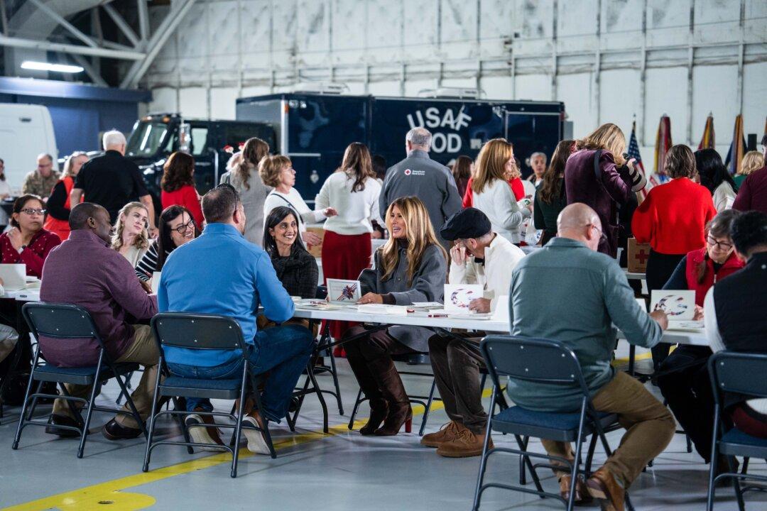 First Lady Melania Trump and Second Lady Usha Vance speak with guests and write cards during the Red Cross holiday care package-building and card-writing event at Joint Base Andrews, Md., on Dec. 1, 2025. (Madalina Kilroy/The Epoch Times)