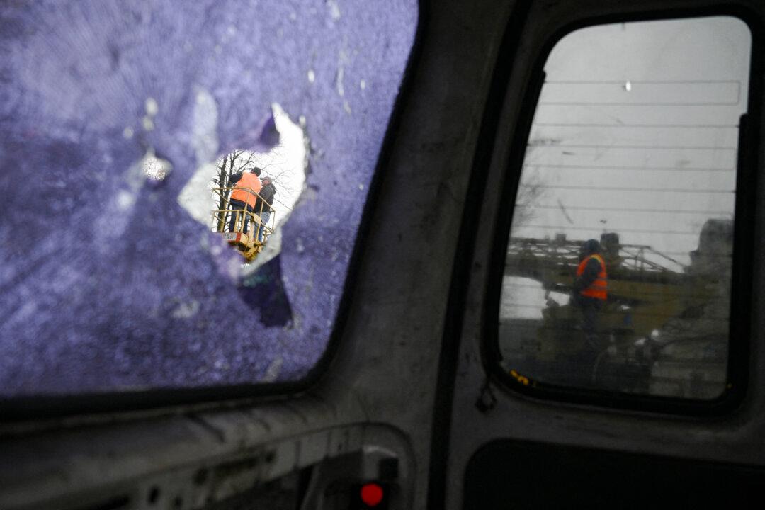 Workers repair a power line near a residential building damaged after a recent Russian air attack in Kyiv, Ukraine, on Dec. 3, 2025. (Genya Savilov/AFP via Getty Images)