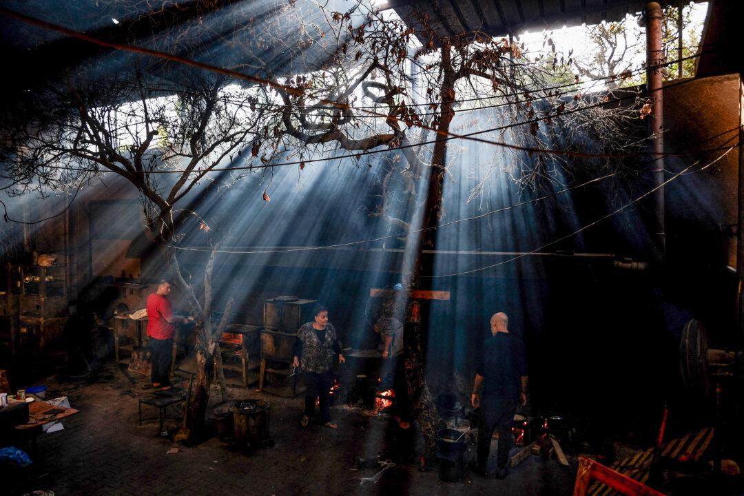 Displaced Palestinians prepare food in a shelter at the Holy Family Catholic Church compound in Gaza City on Dec. 3, 2025. (Omar Al-Qattaa/AFP via Getty Images)