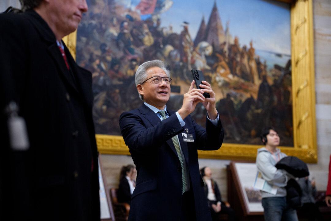 Nvidia CEO and co-founder Jensen Huang stops to photograph the U.S. Capitol Rotunda as he walks toward the office of House Speaker Mike Johnson (R-La.) in Washington on Dec. 3, 2025. Huang was on Capitol Hill to meet with Republicans on the Senate Banking Committee. (Andrew Harnik/Getty Images)