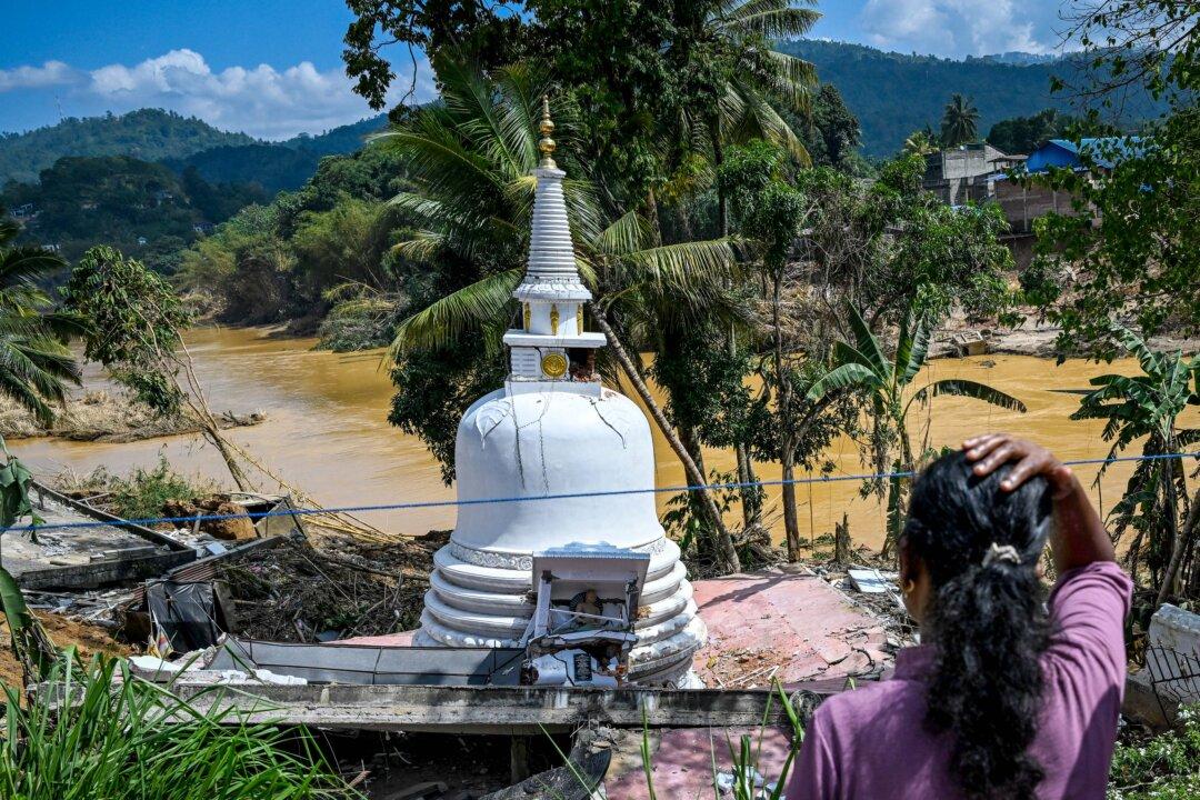 A woman looks at a stupa damaged by landslides in the aftermath of Cyclone Ditwah in Gampola, Sri Lanka, on Dec. 4, 2025. Rain forecasts raised fears of more damage in flood-hit Indonesia and Sri Lanka. (Ishara S. Kodikara/AFP via Getty Images)