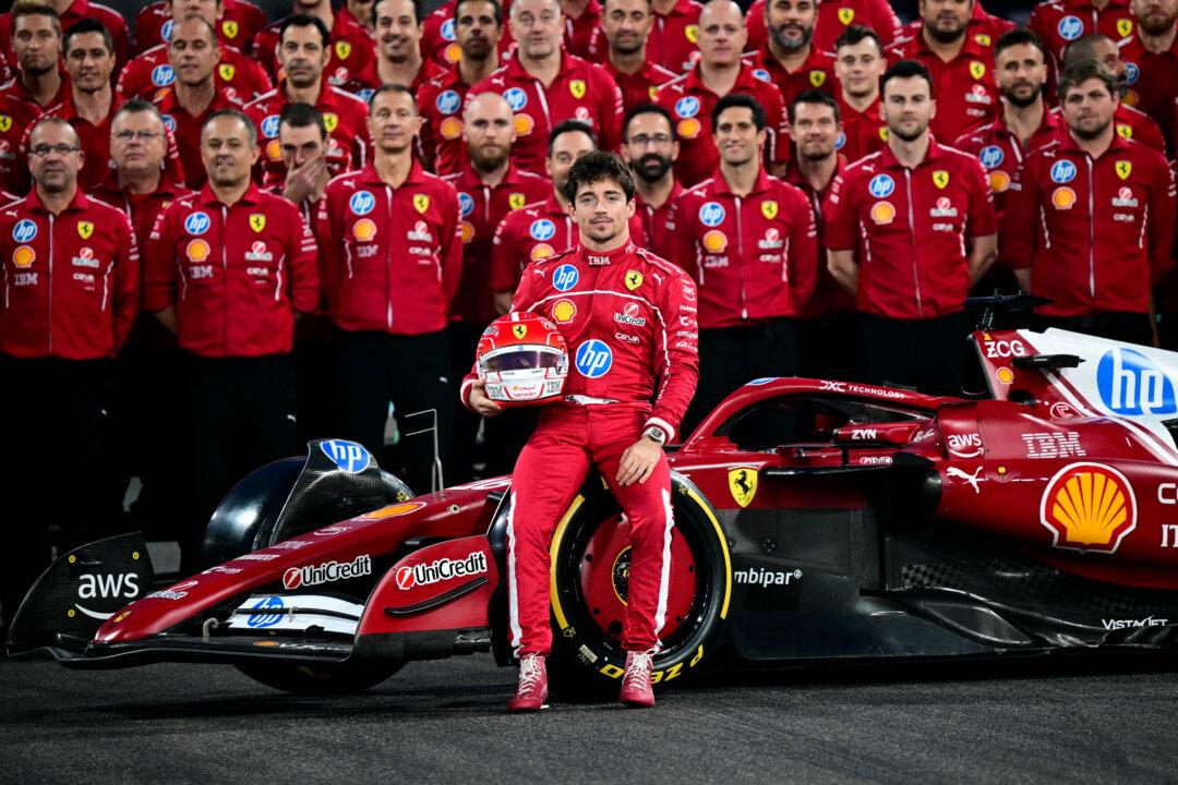Ferrari's Monaco driver Charles Leclerc and the team pose for a group photo ahead of the Abu Dhabi Formula One Grand Prix at the Yas Marina Circuit in Abu Dhabi, United Arab Emirates, on Dec. 4, 2025. (Giuseppe Cacace/AFP via Getty Images)