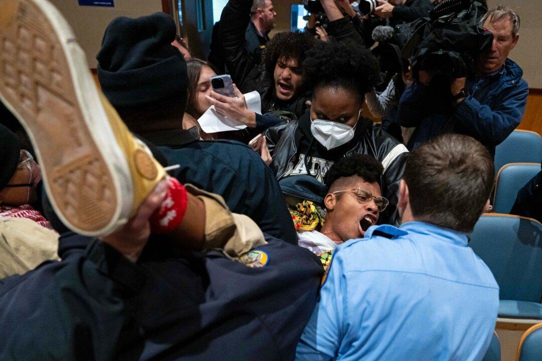 Police remove an anti-ICE and Border Patrol protester from a city council meeting at New Orleans City Hall on Dec. 4, 2025. The Department of Homeland Security announced on Dec. 3 that it has launched Operation Catahoula Crunch to combat illegal immigration in the area. (Adam Gray/AFP via Getty Images)