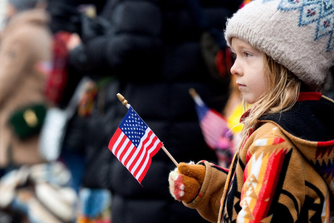 A child holds a U.S. flag during an event in Denver on Jan. 9, 2025. Trump’s Invest America program gives every child under 18 with a Social Security number access to a federally overseen savings and investment account that families can activate beginning July 4, 2026. (Jason Connolly/AFP via Getty Images)