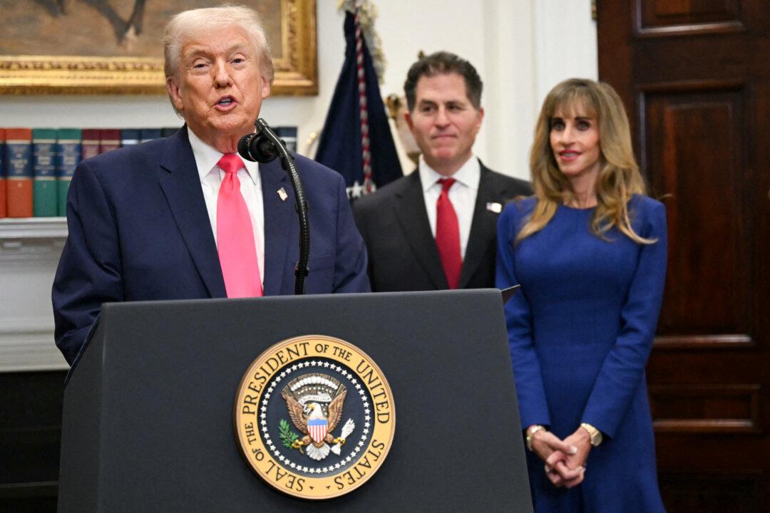 President Donald Trump announces a $6.25 billion donation from Michael Dell (C), CEO of Dell Technologies, and his wife, Susan (R), to “Trump Accounts” at the White House on Dec. 2, 2025. The donation would fund $250 deposits for investment accounts for at least 25 million children aged 10 and under who were born before Jan. 1, 2025. (Andrew Caballero-Reynolds/AFP via Getty Images)
