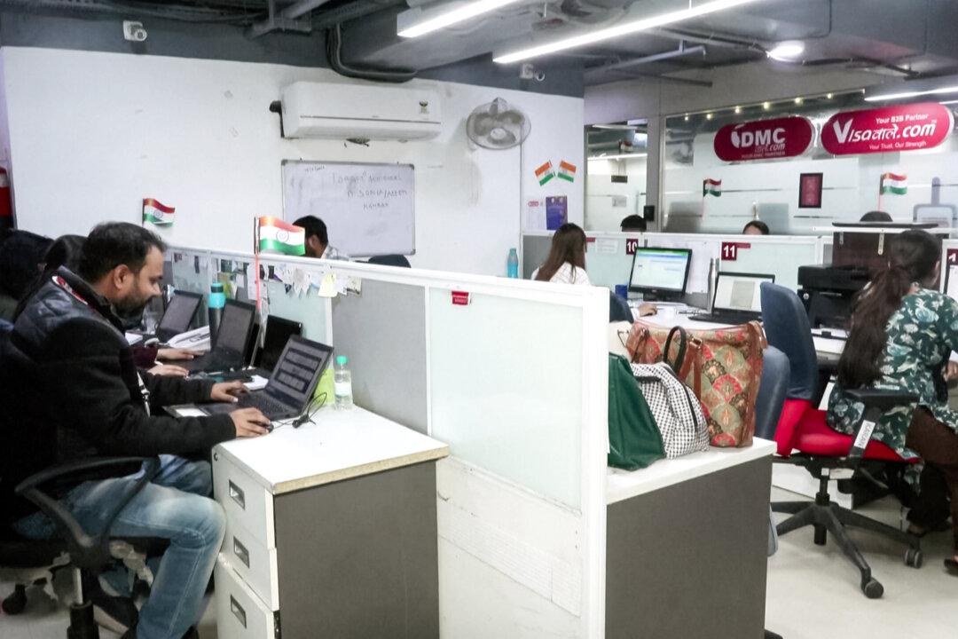 Employees work at Visawaale, a visa facilitation company, in New Delhi, India, on Nov. 28, 2025. In September, President Donald Trump imposed a $100,000 fee on H-1B visas; in recent weeks he has suggested H-1B workers can help train Americans for the high-paying jobs he hopes to bring back to the United States. (Reuters/Screenshot via The Epoch Times)