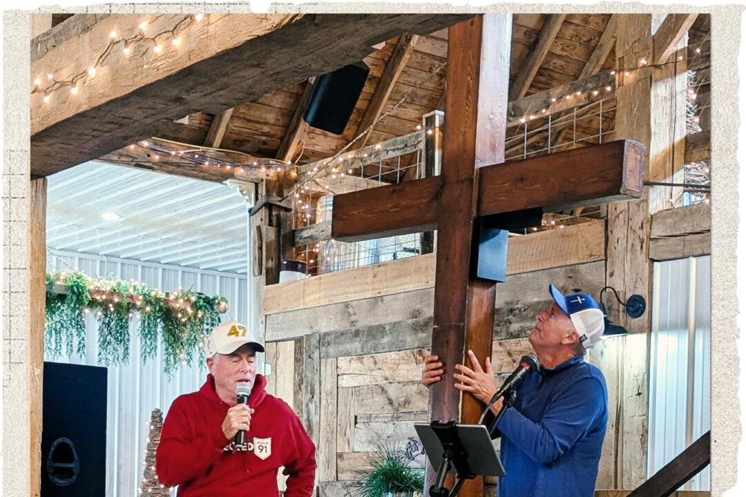 Jeff Louderback (back) holds a 10-foot-tall, 65-pound wooden cross at a Faith, Freedom, and MAHA event in Hillsboro, Ohio, in October 2025. Regular intermittent fasting and occasional 72-hour water fasts are part of Louderback’s ongoing wellness journey. (Courtesy of Lake View Loft Event Venue)