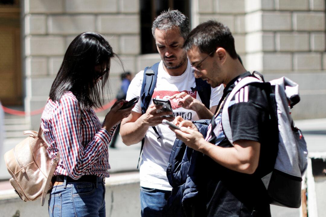 People look at their smartphones in New York City, on May 8, 2019. (Reuters/Mike Segar)