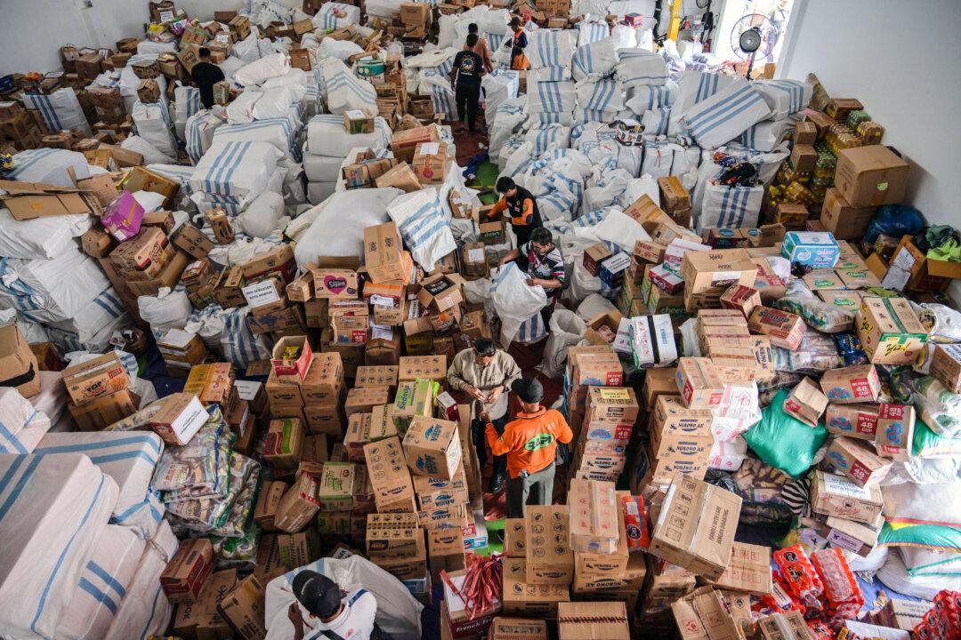 Volunteers pack supplies to be delivered to areas affected by flooding at a Regional Disaster Mitigation Agency in Sidoarjo, Indonesia, on Dec. 5, 2025. (Juni Kriswanto/AFP via Getty Images)