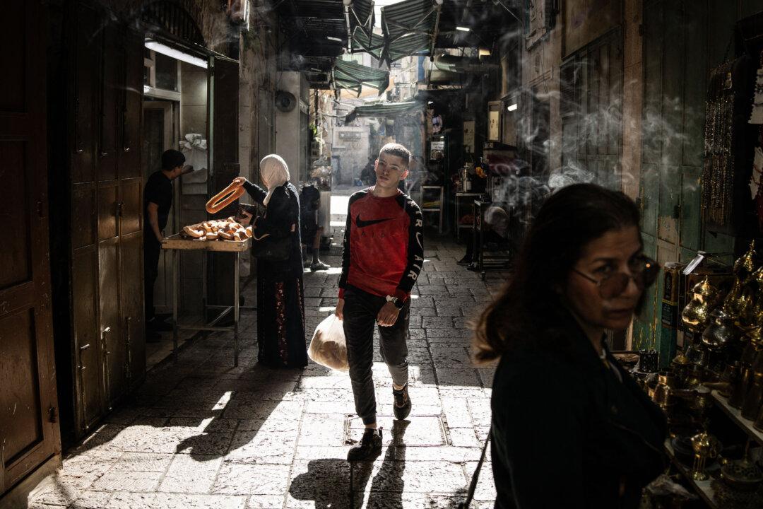A youth carries a bag of flatbread as he walks along a street in the old city of Jerusalem on Dec. 5, 2025. (John Wessels/AFP via Getty Images)