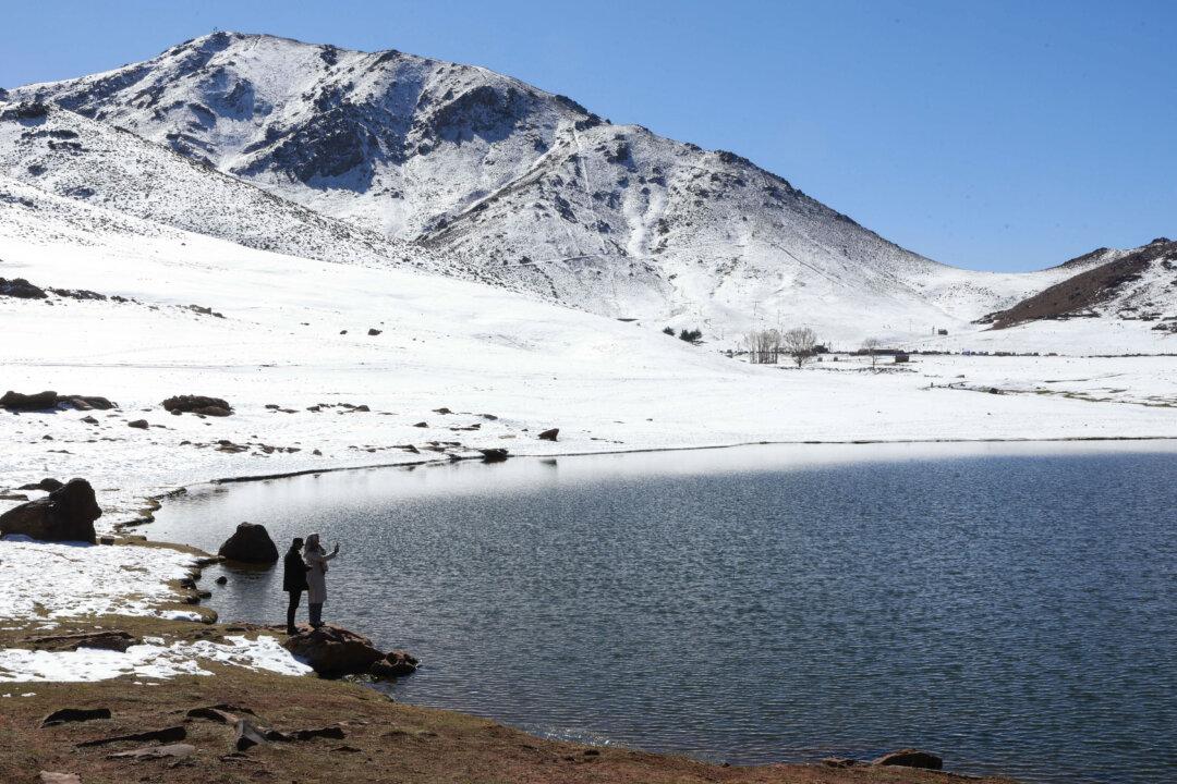 People take pictures from the edge of a lake after the first snowfall at the Oukaimeden ski station in Morocco's Al Haouz region in the High Atlas, on Dec. 5, 2025. (Abdel Majid Bziouat / AFP via Getty Images)