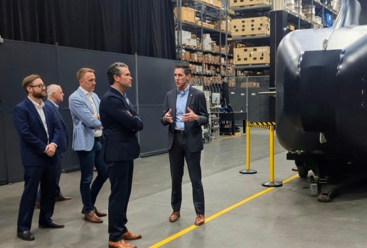 Andrew Nuss (R), head of growth and strategy for the maritime division of Anduril Industries, speaks with War Secretary Pete Hegseth about the Dive-XL underwater autonomous vehicle program during a tour of Anduril's corporate campus in Costa Mesa, Calif., on Dec. 5, 2025. (Ryan Morgan/The Epoch Times)