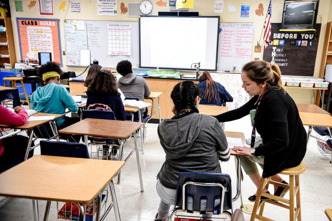 A teacher works with her students in a science class in a high school in Homestead, Fla., on March 10, 2017. Although Florida's curriculum changes affect students only through the end of high school, Lourdes Cotanda-Ercia said she is concerned about the pro-socialist environment college professors maintain in higher education. (Rhona Wise/AFP via Getty Images)