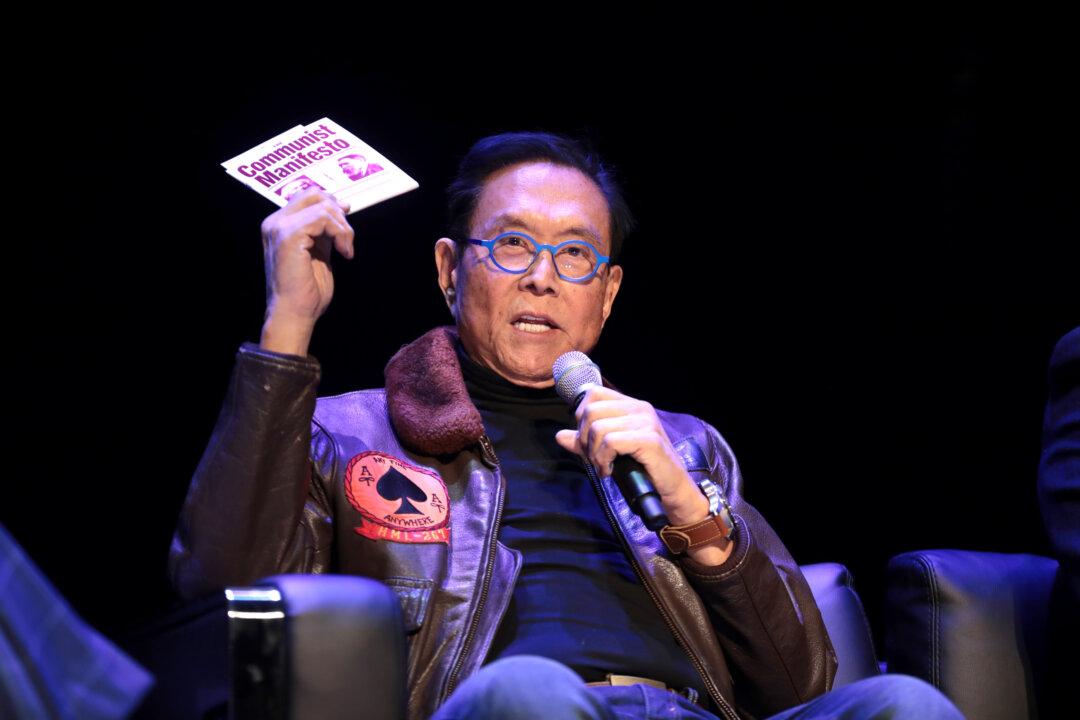 Robert Kiyosaki holds a copy of “The Communist Manifesto” while speaking with attendees at an Arizona State University event in Tempe, Ariz., on Feb. 8, 2023. Kiyosaki said his college economics professor urged him to read Karl Marx’s book to “know your enemy.” (Gage Skidmore/Flickr)