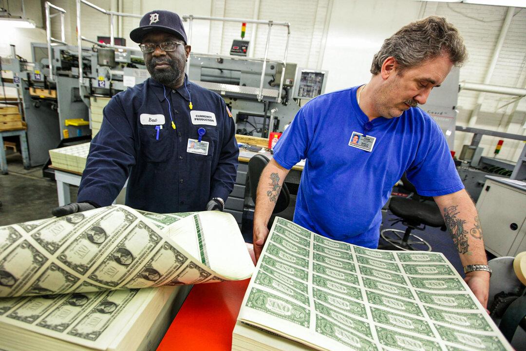 Workers loosen a stack of $1 bills on a vibrating table before they are cut into singles at the Bureau of Engraving and Printing in Washington on March 26, 2009. (Mark Wilson/Getty Images)